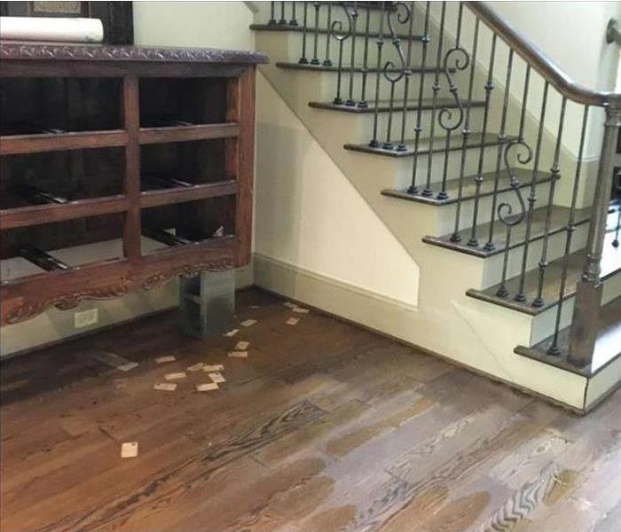 water damaged planked flooring and staircase walls