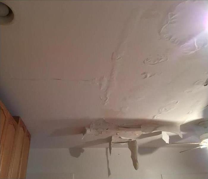 blistered ceiling and hanging debris from water soaking